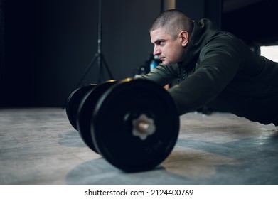 Strong and well built bodybuilder using dumbbell weights while training in the gym. Fitness exercise. Weight training concept.