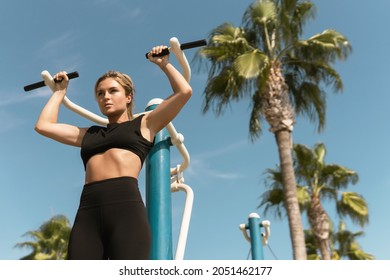 Strong woman athlete during her workout in outdoor gym - Powered by Shutterstock