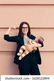 Strong Woman In Business Outfit Holding Baby. Female Role Model Being A Strong Mom And An Entrepreneur
