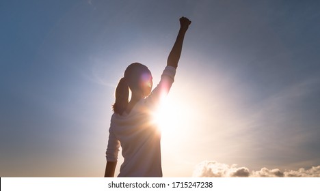 Strong woman with fist up to the sky. People, mental strength, power, victory, and never giving up concept. 