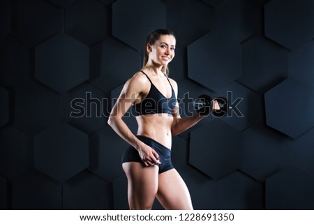 Similar – One young athletic woman at crossfit training, exercising with trx suspension fitness straps over dark background, front view, looking at camera