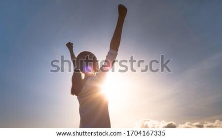 Strong woman overcoming adversity. Woman with fist up to the sky. People power and strength concept. 