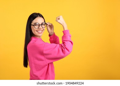 Strong Woman As Symbol Of Girl Power On Yellow Background, Space For Text. 8 March Concept