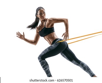 Strong woman using a resistance band in her exercise routine. Photo of woman performs fitness exercises on white background.