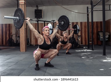 Strong women bodybuilder doing overhead with heavy barbell in modern gym. Functional training class. Bodybuilding and Fitness - Powered by Shutterstock