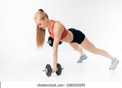 strong young fit girl is fond of bodybuilding. handstand push-up with dumbbells. full length shot