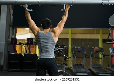 Strong Young Man Seen From Behind Working Out At The Gym. Male Fitness Coach Training 