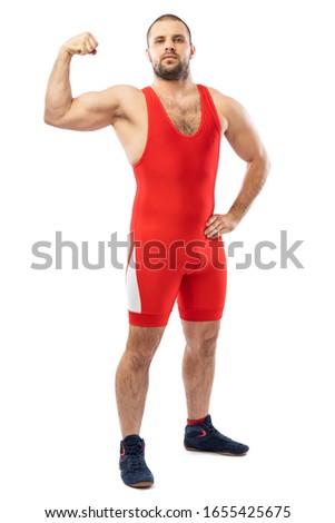 Strong strong young man in a sports red tights stands showing biceps, looking confidently forward on a white isolated background. Concept of athlete, Greco-Roman wrestler for sports design.
