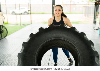 Strong Young Woman Lifting A Tire And Doing Tire Flip Exercises For Her Cross Training Workout