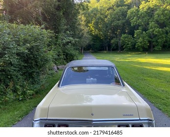 Stroudsburg, PA USA - July 13, 2022 : The Back Trunk Of A Vintage Yellow 1972 Dodge Dart Car With A Metal Bumper Parked On A Country Driveway