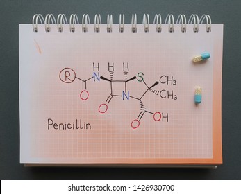 Structural Chemical Formula Of Antibiotic Penicillin Molecule Written On The Notebook With Blue Pills. General Formula Of Penicillin, Where R Is A Variable Group.