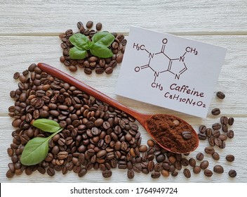 Structural chemical formula of caffeine molecule with roasted coffee beans and wooden spoon filled with coffee powder. Caffeine is a central nervous system stimulant, psychoactive drug molecule. - Shutterstock ID 1764949724