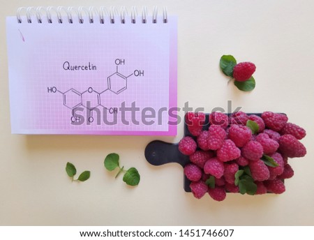 Structural chemical formula of quercetin molecule with fresh sweet raspberries. Berries as a rich source of various polyphenols, including the flavonoid quercetin. It has a variety of health benefits.