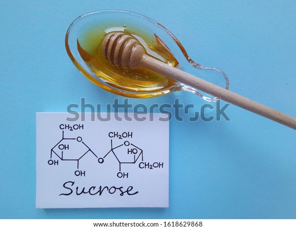 Structural chemical formula of sucrose molecule\
with a bowl of honey. It is a disaccharide molecule composed of\
glucose and fructose. Honey gets its sweetness from fructose,\
glucose, and\
sucrose.