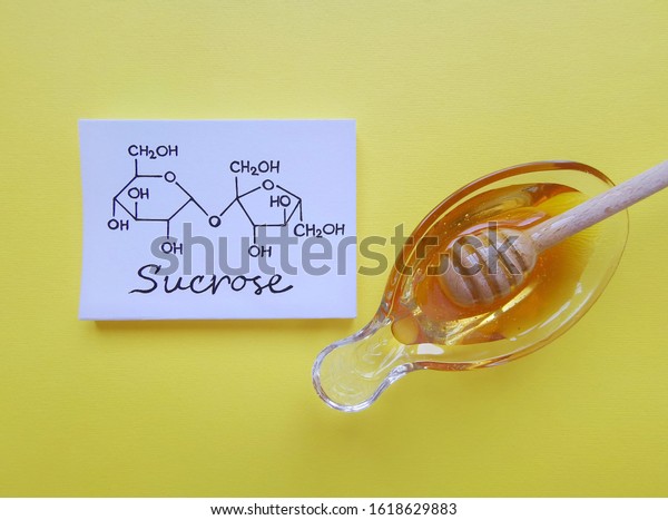 Structural chemical formula of sucrose molecule\
with a bowl of honey. It is a disaccharide molecule composed of\
glucose and fructose. Honey gets its sweetness from fructose,\
glucose, and\
sucrose.
