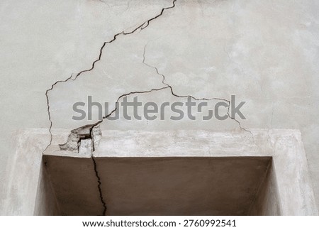 Structural damage Cracks in the plaster in a facade with a window