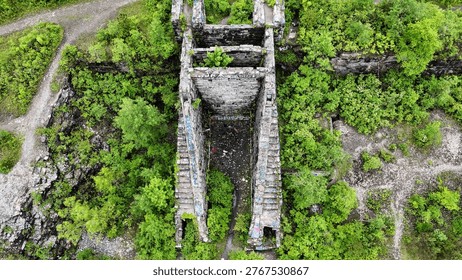 A structural edifice that acts as the gateway to a network of underground tunnels surrounded by vibrant green vegetation.