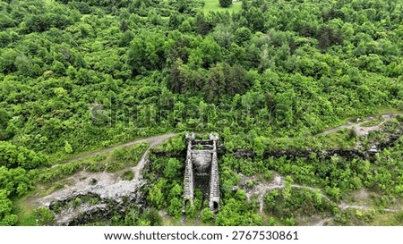 A structural edifice that acts as the gateway to a network of underground tunnels surrounded by vibrant green vegetation.