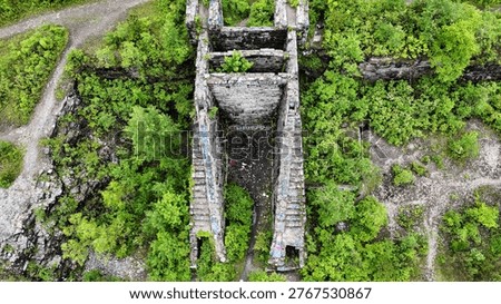 A structural edifice that acts as the gateway to a network of underground tunnels surrounded by vibrant green vegetation.