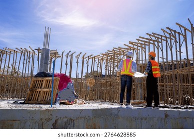 Structural engineer, architect and foreman worker with blueprints discuss, plan working for the outdoors building construction site. Construction collaboration concept