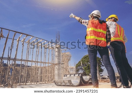Structural engineer or architect and foreman worker with blueprints discuss, plan working for the outdoors building construction site. Selected focus