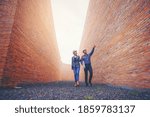 Structural engineer and architect working with blueprints discuss at the tall wall building structure, outdoor construction site