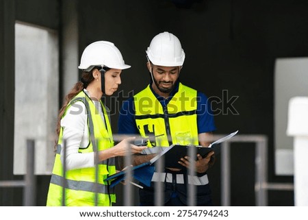 Structural engineer and foreman worker with touch pad discuss, plan working for the outdoors building construction site.