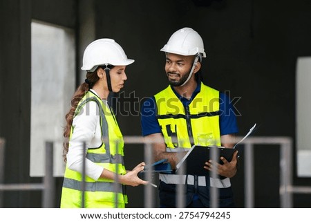 Structural engineer and foreman worker with touch pad discuss, plan working for the outdoors building construction site.