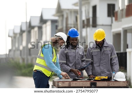 Structural engineer and foreman worker with touch pad discuss, plan working for the outdoors building construction site. civil engineer or architect on construction site