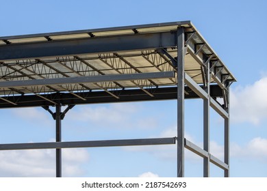 Structural Steel Construction Vertical Supports And A Horizontal Roof Deck Against A Blue Sky