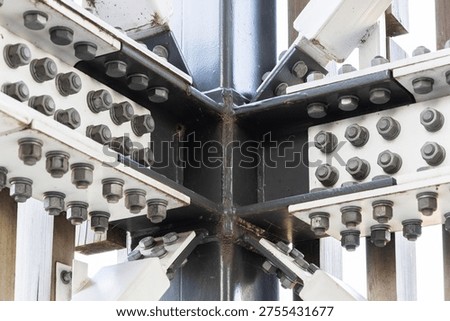 Structural steel joint featuring heavy duty bolts and iron plates. This industrial connection is commonly used in skyscraper framework and building infrastructure.