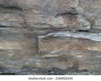 The structure of the old stone masonry. Gray wall. Old cement joints. Pattern
