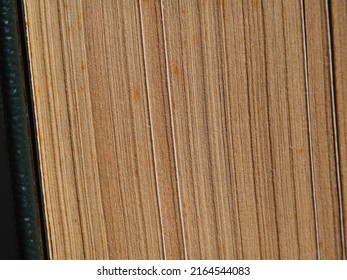 The Structure Of The Old Vintage Yellowed Pages Of A Hardcover Book Side View Wide Abstract Rough Texture Of The Background. Macro View Of Old Vintage Book Pages