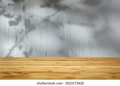 Structure and shadow on a wall with an empty wooden table 