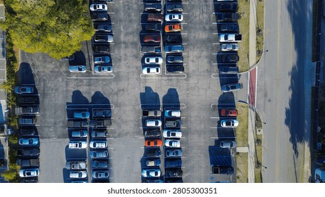 Structured parking rows display high density vehicle arrangement across asphalt surface. Marked stalls organize orderly transit flow between landscaped green areas within North Charleston, SC. USA