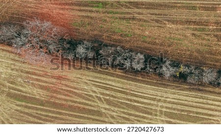 A structured pattern of crisscross plow lines spreads across a large winter field.