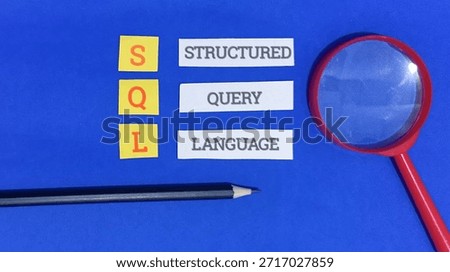 Structured query language sql is defined using small paper cards arranged vertically spelling out the letters next to the full corresponding words structured query language while a red magnifying glass.