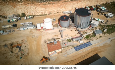 Structures Of Plant Producing Sand, Crushed Stone, Cement And Batching Concrete And Asphalt. Mixer Trucks, Concrete Pumping Machines, Gas Tanks And Silos Aerial View. Construction Materials Production