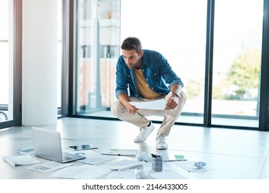 Structuring A New Game Plan. Shot Of A Young Businessman Brainstorming With Paperwork On A Floor In An Office.