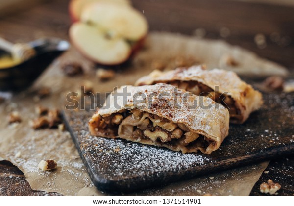 Strudel\
with apples and nuts. Composition  of delicious bakery products.\
Apple pie, cinnamon, honey, apples and\
walnuts.