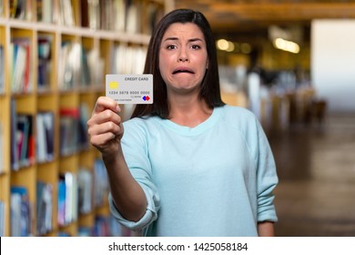 Struggling College Student Holding Mockup Bank Credit Card, In Debt After Paying For Books And Expensive Tuition Fees