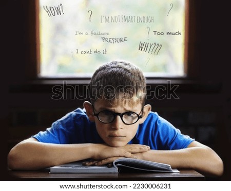 Struggling to learn - Learning disabilities. Young boy feeling overcome with boredom in the classroom.