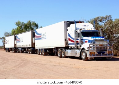 STUART HIGHWAY, AUSTRALIA - December 1, 2015. Very Long White Truck Trailer, Australian Roadtrain, Transports Heavy Freight Cargo On Rural Outback Road. Road Train Logistics.