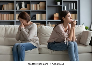 Stubborn Adult Daughter And Mature Mother Ignoring Each Other After Family Quarrel, Sitting On Couch Separately Back To Back, Young Woman And Upset Older Mum Not Talking After Fight