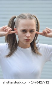 Stubborn, Headstrong Teen Age Girl, With Fingers In Her Ear, She Does Not Want To Listen. Education Problem