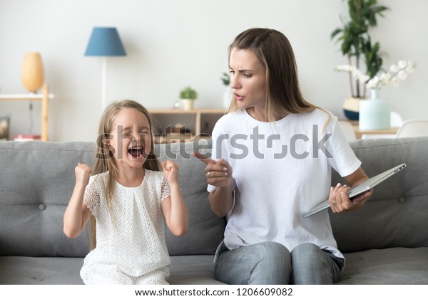 Stubborn little girl scream loud not listening to\
strict mom, serious young mother scold shouting daughter for bad\
behavior, working mommy lecture kid yelling asking attention.\
Family conflict\
concept