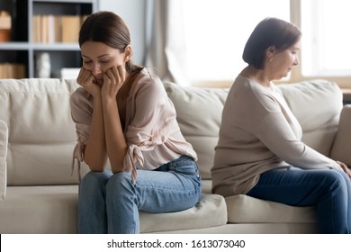 Stubborn Middle-aged Mother And Grown-up Daughter Sit Separately Back To Back On Sofa In Living Room Avoid Talking After Fight, Upset Distressed Senior Mum And Adult Child Ignore After Family Quarrel