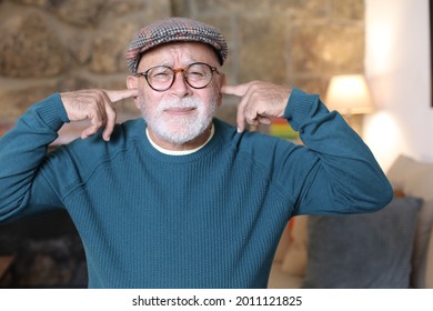 Stubborn Senior Man Blocking Ears With Fingers