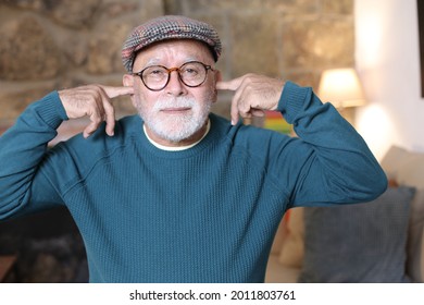 Stubborn Senior Man Blocking Ears With Fingers