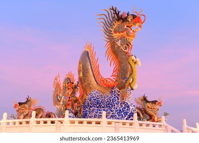 Stucco dragons decorated with colorful ceramics glitter and reflect the beautiful lights in the early twilight hours. - Shutterstock ID 2365413969